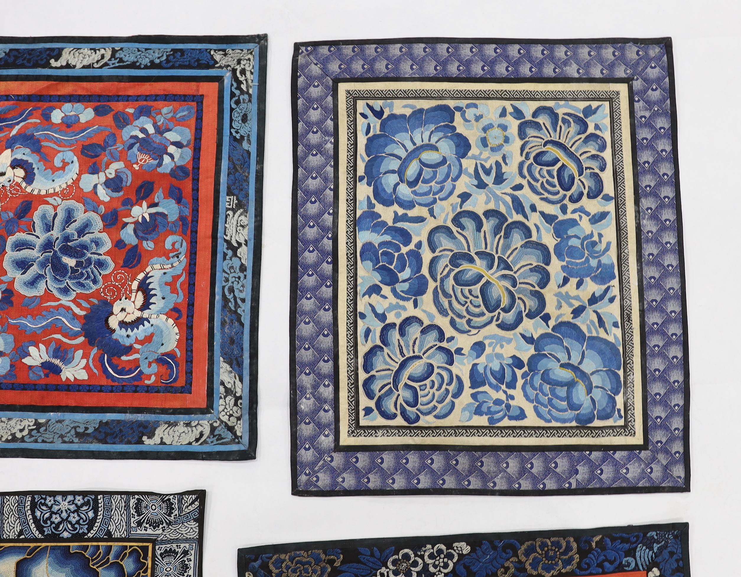 Six large Chinese silk embroidery mats with silk brocade borders, mostly embroidered flowers and butterflies in stem stitch and Beijing knot, largest 44.5cm x 37cm